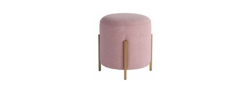 A round light pink ottoman with gold legs